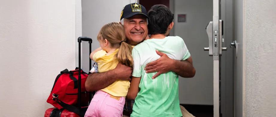 Senior military veteran hugging grandchildren