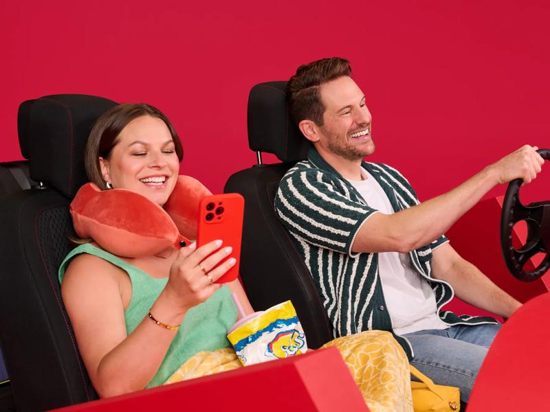 Young couple in car using mobile phone