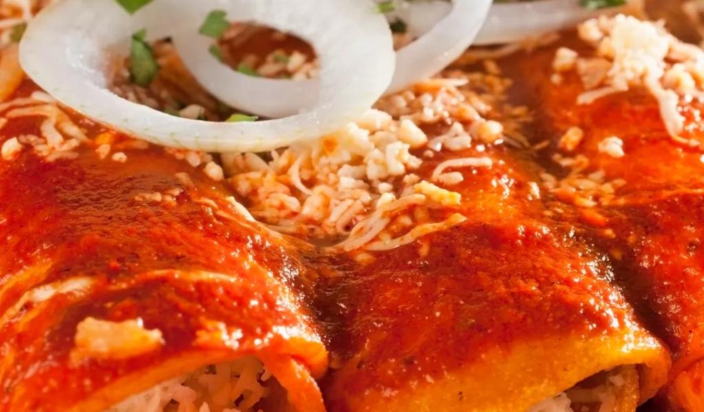 Close-up of enchiladas topped with sauce and onions