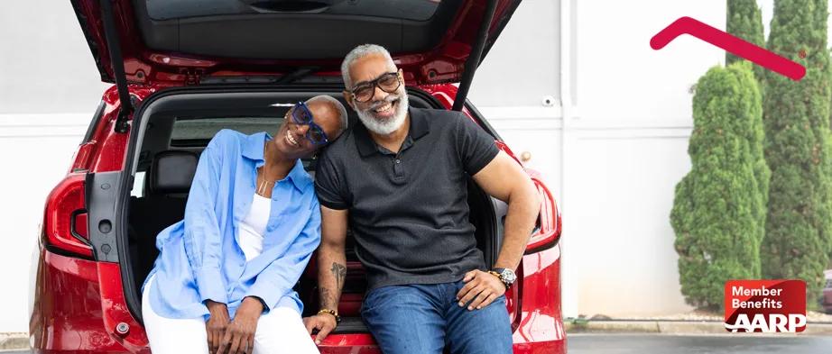 Couple Sitting on Car with the Trunk Open