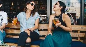 friends holding beers on a patio