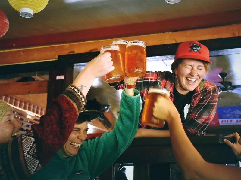 people raising glasses next to red icon of martini