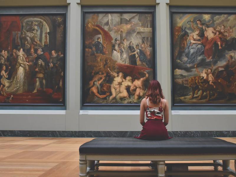 woman looking at paintings