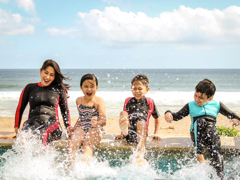 mom and kids splashing at the beach