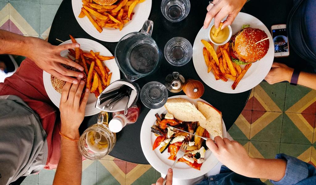 Friends eating burgers overhead