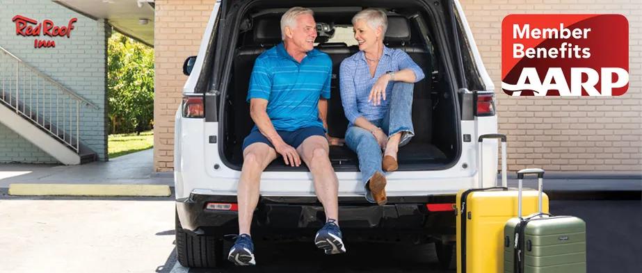 AARP image of senior couple sitting in back of car