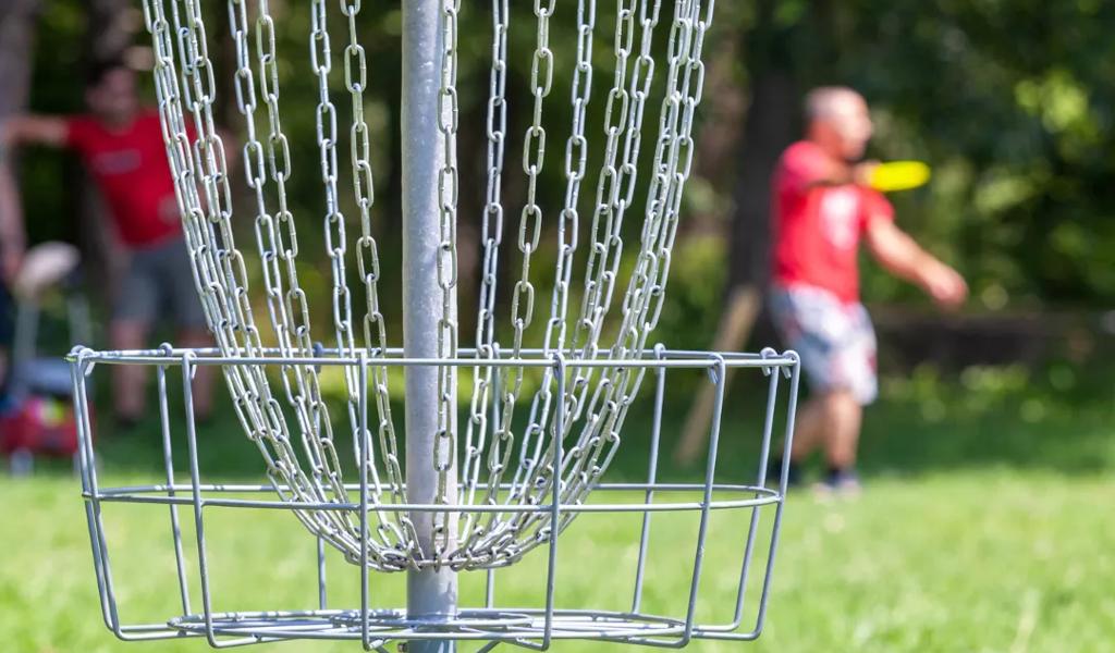 Disc golf basket on grassy field