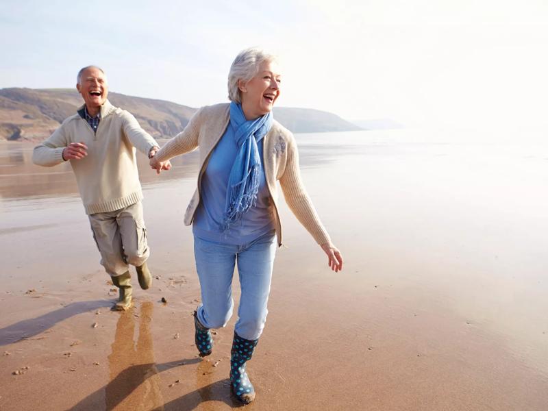 senior travel couple on beach