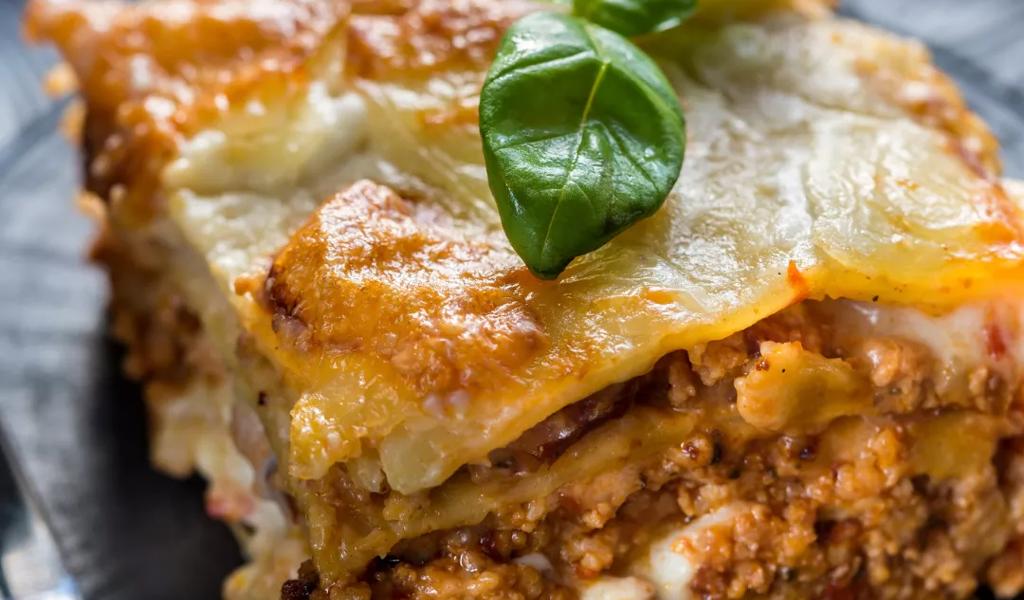 Slice of lasagna garnished with fresh basil