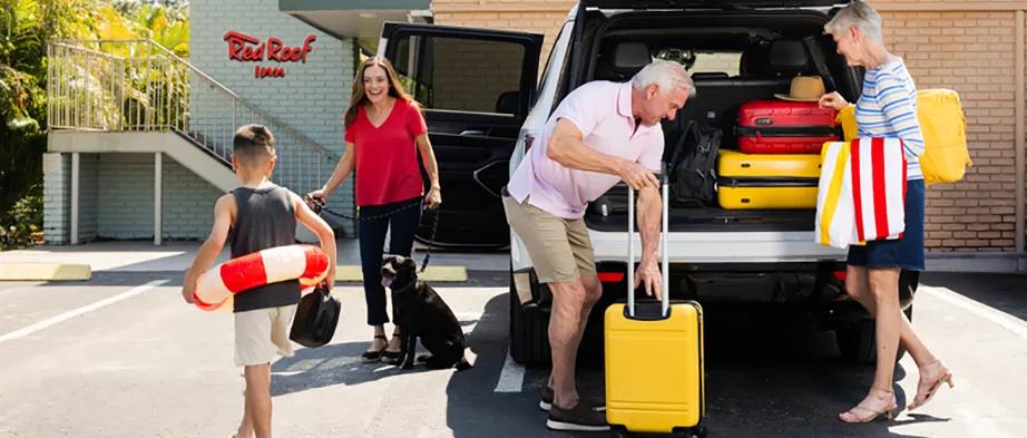 Family unpacking luggage from vehicle