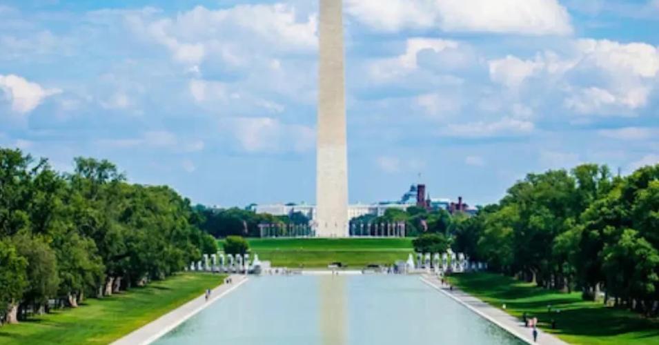 Washington Monument reflected in the Lincoln Memorial Reflecting Pool on a sunny day in Washington, DC.