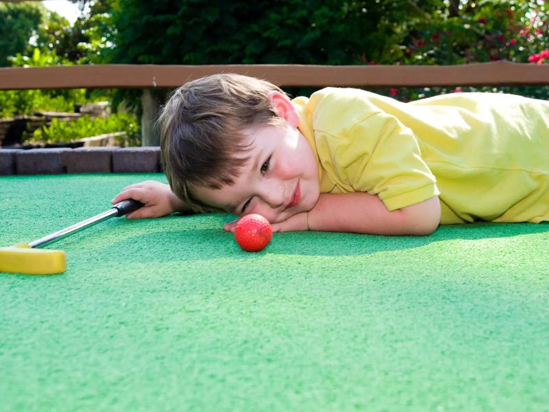 child playing putt putt